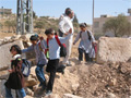 Palestinian schoolchildren cross a roadblock 